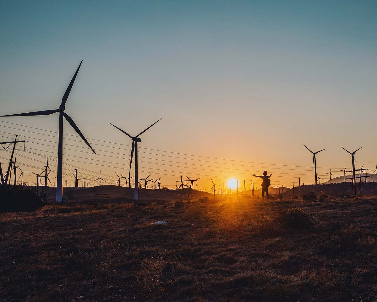 motor silhouette photography of person standing near windmill machine